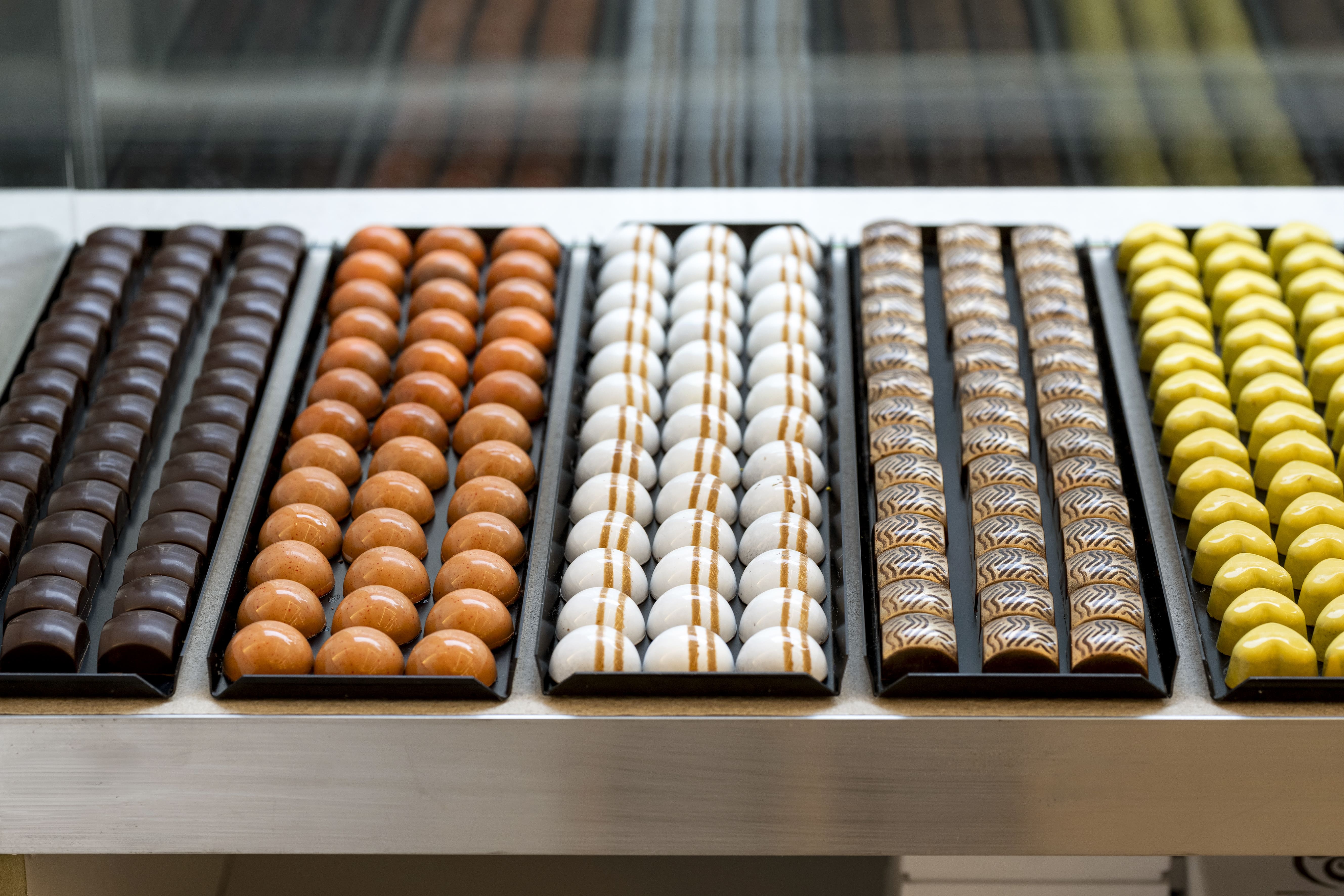 Comptoir de la chocolaterie Plaisirs Chocolatés à Bruxelles
Présentation des chocolats artisanaux en boutique
Comptoir de dégustation de chocolats belges
Sélection de pralines au comptoir
Chocolats exposés dans notre boutique artisanale