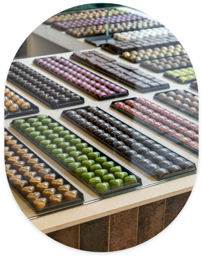 Comptoir de la chocolaterie Plaisirs Chocolatés à Bruxelles
Présentation des chocolats artisanaux en boutique
Comptoir de dégustation de chocolats belges
Sélection de pralines au comptoir
Chocolats exposés dans notre boutique artisanale